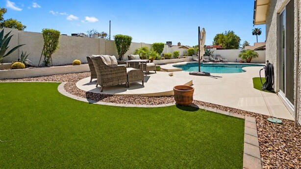 A backyard with a swimming pool, patio furniture, and a well-maintained lawn. - Dive In Desert - 3Bd - Pool Oasis (Chandler)