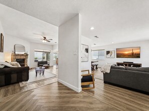 A spacious living area with a fireplace, sofas, and a dining table.