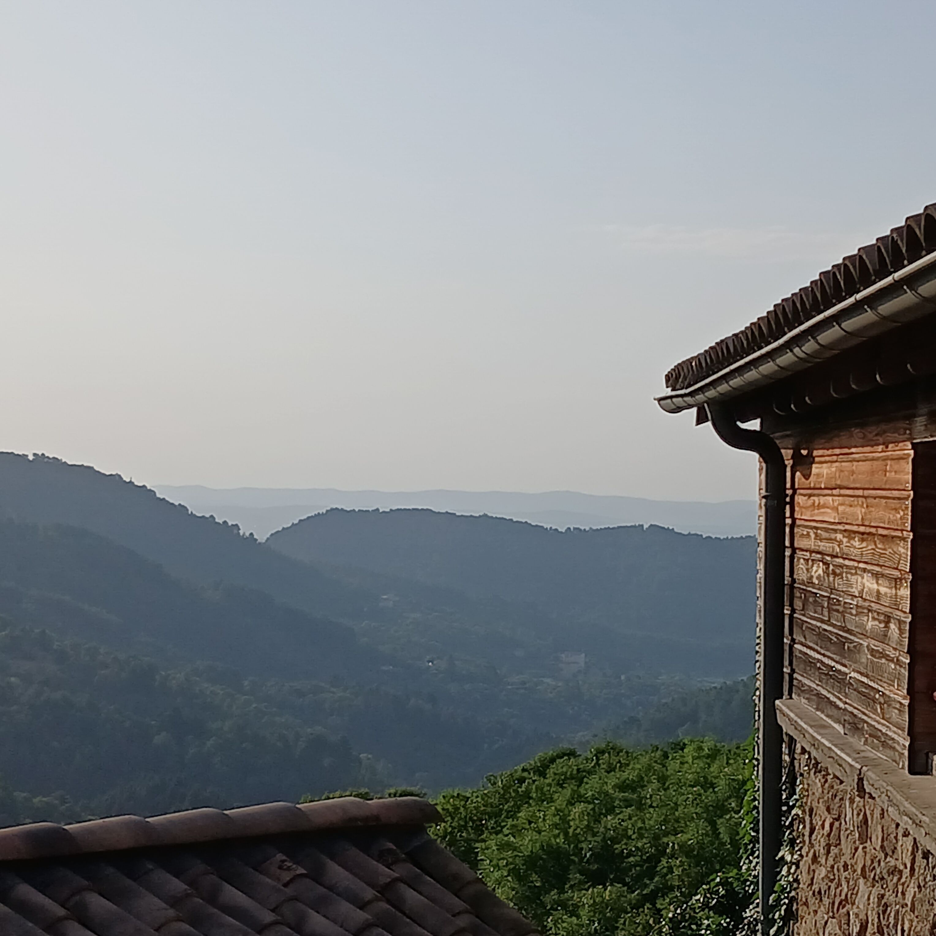 Un edificio tradicional con techo de tejas, con vistas a un paisaje montañoso.