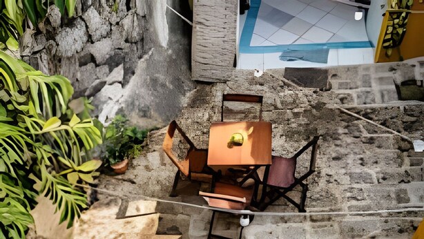 A stone staircase leading to outdoor seating with tables and chairs. - Chalé da Libélula 3: Refuge close to the beach (Ilhabela)