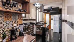 Une cuisine moderne dotée d’un îlot central, d’une cuisinière encastrée et d’un réfrigérateur.