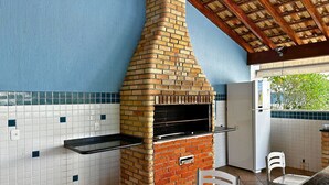 Eine Küche mit Backofen, weißen Fliesen und Holzboden.
