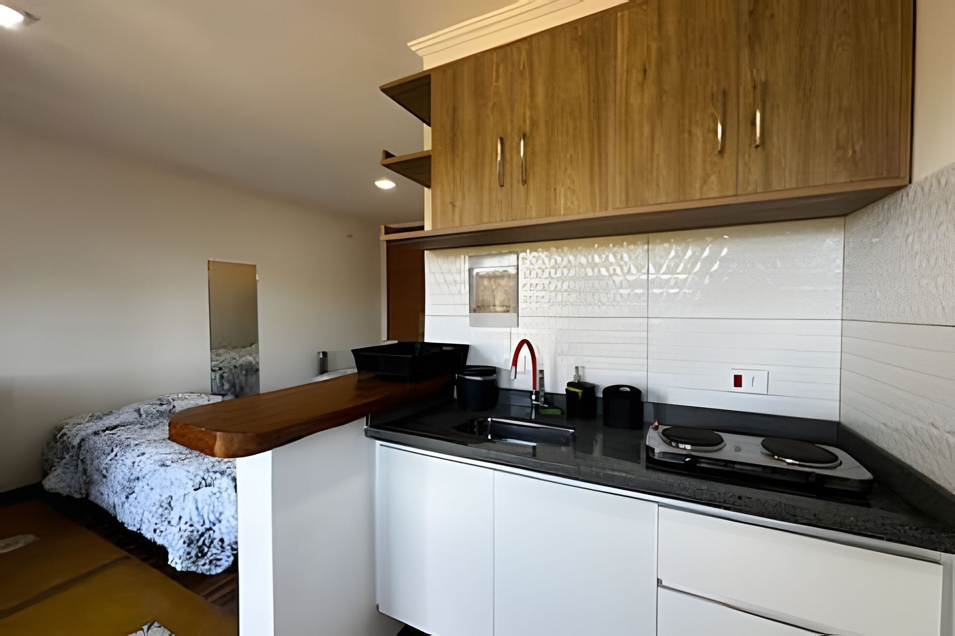 Una cocina compacta con armarios de madera, una encimera y una estufa.