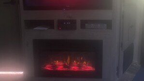 Une cheminée avec un écran de télévision affichant le logo de Netflix.