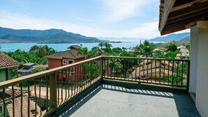 A balcony with a view of a lake and mountains. - Ponta do Sol | 4 suítes, piscina e churrasqueira (Ilhabela)