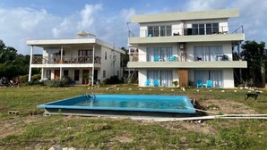 A two-story building with a swimming pool in front.