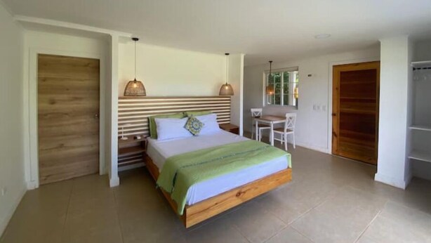 A bedroom with a wooden bed, a desk, and a chair.