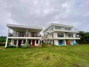 A two-story building with a flat roof and a balcony on the upper floor.