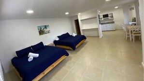 A room with two beds, a small kitchenette, and a dining area. - Savannah Inn 204 Studio AC,Wifi,TV, (San Andrés y Providencia)