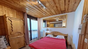 A wooden-paneled room with a bed, a wardrobe, and a mirror. - 50m from ski slopes, Ground floor, view parking, parking, tv, ski locker, 12m², Les 2 Alpes (Les Deux Alpes)