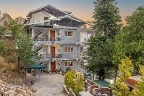 Un immeuble à plusieurs étages doté de balcons, d’un escalier et d’une cour intérieure.