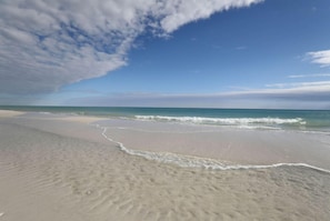 A beach with a sandy shore and gentle waves.