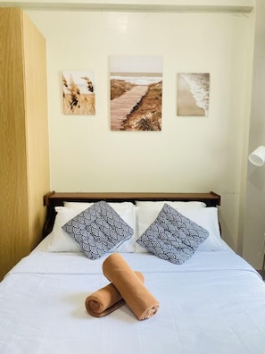Tabla de planchar con plancha y ropa de cama