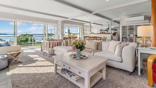 Un salon spacieux avec un grand canapé, une table basse et une vue sur la mer.