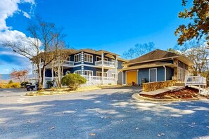 Une maison à deux étages avec un garage, une véranda et une allée.
