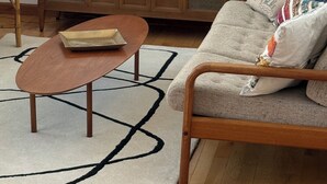 A living room with a sofa, a wooden cabinet, two lamps, and a coffee table.