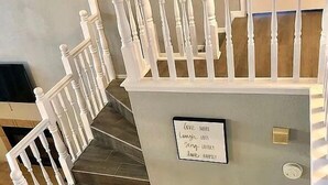 A staircase with white balusters and a sign on the wall.