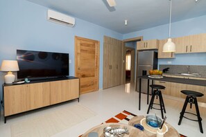 Une cuisine moderne avec des meubles en bois, un four encastré et un coin repas équipé de tabourets.