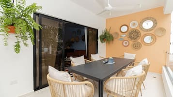 A dining area with a table, chairs, and a ceiling fan.