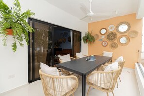 Un comedor con una mesa, sillas y un ventilador de techo.