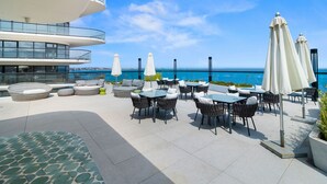 Terraza en la azotea con mobiliario exterior, piscina y vistas al océano.