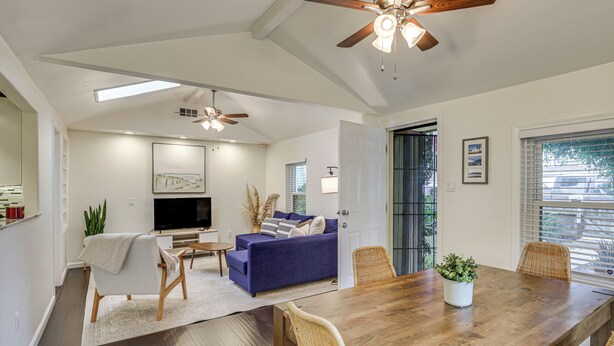 A spacious living area with a wooden dining table, blue sofa, and a ceiling fan. - 2 Mi to Ocean: Pet-Friendly Imperial Beach Retreat (Imperial Beach)
