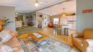 A spacious living room with a coffee table, sofas, and a dining area with chairs. - 1 Mi to Silver Lake Sand Dunes: Deck, Grill & Yard (Mears)