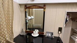 Ein Badezimmer mit Waschtischspiegel, Toilettenpapier, einer Lampe und einem Handtuchhalter.