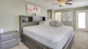 A bedroom with a bed, a nightstand, a dresser, a ceiling fan, and artwork on the walls. - Explore ABQ & Rancho Rio: Family Home w/ Patios! (Rio Rancho)