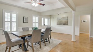 A spacious dining area with a wooden table and chairs, a ceiling fan, and large windows. - Near Rev & Civil War History Museums! Camden Home (Camden)
