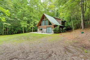 A cabin with a sloped roof, wooden exterior, and a small porch.