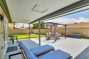 A covered patio area with lounge chairs, a table, and a pergola. - Welcoming Group Getaway w/ Pool & Patio in Peoria! (Peoria)