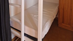 A bunk bed room with a wooden wardrobe.