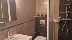 A modern bathroom with a sink, toilet, and shower.
