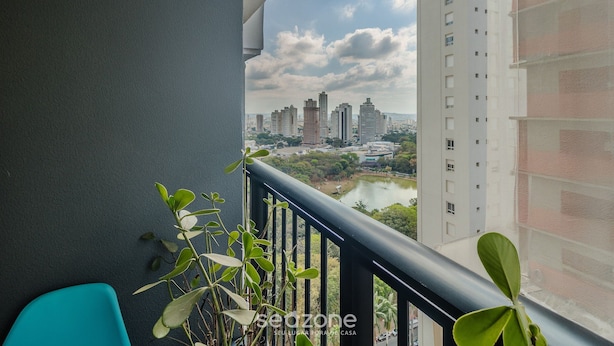 A balcony with a view of a cityscape, including high-rise buildings and a river. - Apart w/ a Suite 290m From Vaca Brava Park Obd2108 (Goiânia)