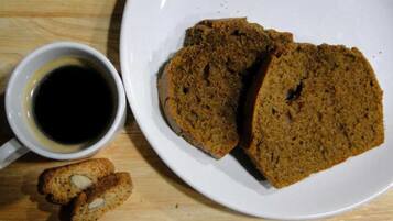 Une assiette avec des tranches de pain et une tasse de café sur une table en bois.