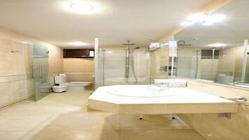 A modern bathroom with a large mirror, a freestanding bathtub, and a toilet.