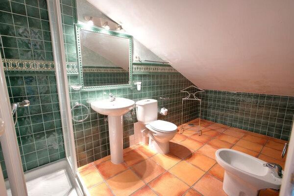 A bathroom with a sink, toilet, and bidet.