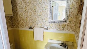 A bathroom with a toilet, sink, and mirror. - Victory Bungalow - 2 bed / 1.5 bath - AC-Affordable-Clean - Sleeps 6+ Avalon, NJ (Avalon)