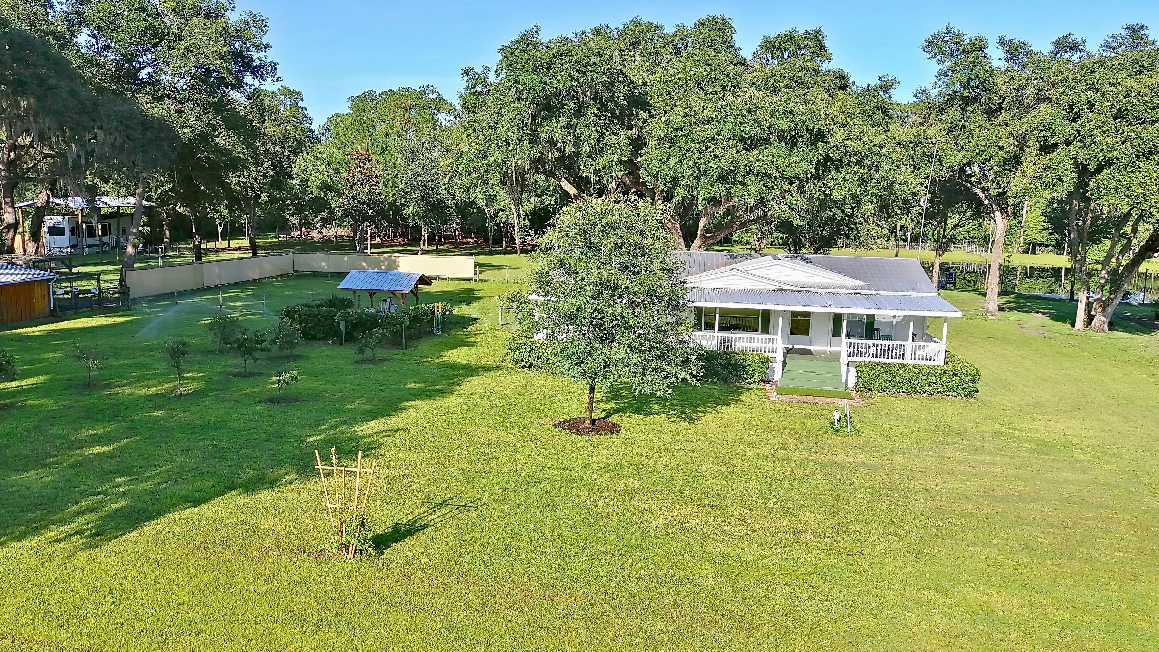 A residential property with a well-maintained lawn, a small garden, and a house with a porch.