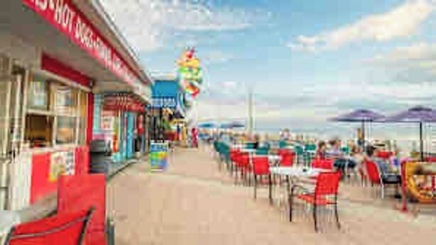En restaurant ved stranden med udendørs siddepladser og havudsigt.