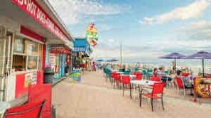 Un restaurante frente a la playa con terraza y vista al mar.