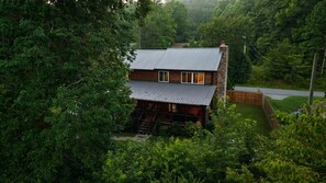 Une cabane surmontée d’un toit en métal, entour ée d’une forêt dense.