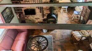 Ein mehrstöckiger Wohnbereich mit Kamin, Sitzecke und Fernseher.