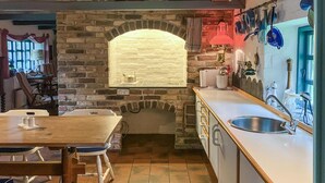 Eine Küche mit Steinwand, Holztisch und Spüle.