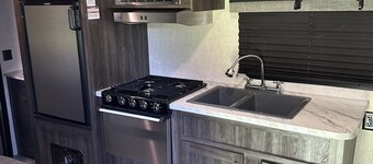 Cozy camper with queen Murphy bed, bunks, and dinette conversion bed.