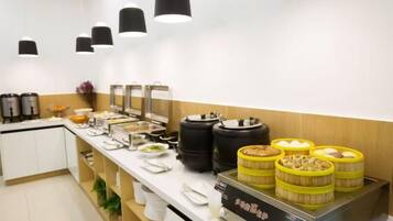 A buffet setup with various food containers, a coffee station, and a water dispenser.