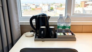 A hotel room with a window view, a tray with a coffee maker, two water bottles, and a tea set. - Homeinn Pebble Hotel (Tongling Zhidicheng Fortune Plaza Third Middle School) (Tongling)
