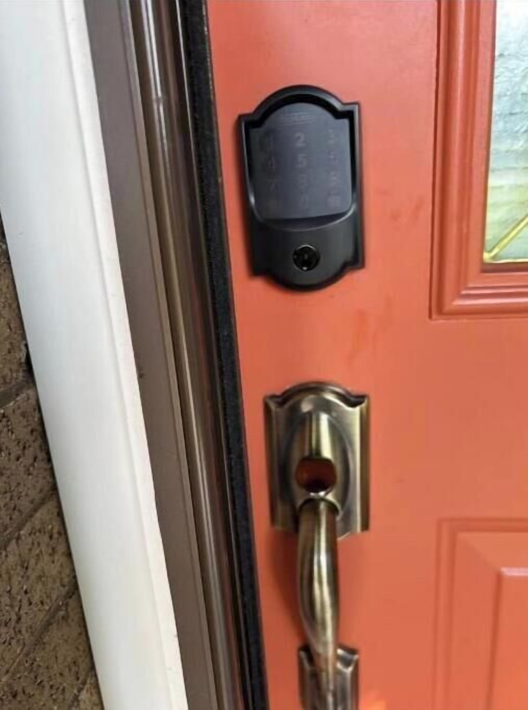 A door with a black electronic keypad lock and a traditional keyhole lock.