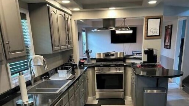 A modern kitchen with stainless steel appliances, a built-in oven, and a flat-screen TV mounted above the counter. - Home away from home (Indiana)